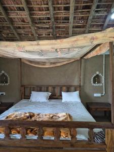 Kirti kewat Homestay في Maheshwar: غرفة نوم بسرير وسقف خشبي