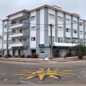 um grande prédio branco em uma rua com uma seta amarela em 4 Mares em Punta del Este