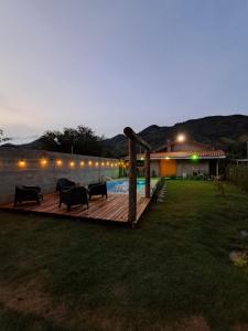 a deck with chairs and a swimming pool at night at Refúgio dos Sonhos in Gonçalves