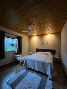 a bedroom with a large bed and a wooden ceiling at Refúgio dos Sonhos in Gonçalves +28 photos
