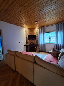 a large couch in a living room with a television at Refúgio dos Sonhos in Gonçalves