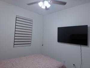 a bedroom with a flat screen tv and a bed at Close to Florida Keys in Florida City