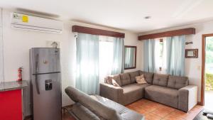 坦波Pura Vida Villa! Beachfront Golf and Country Club Los Delfines 24 hours security的带沙发和冰箱的客厅