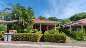 坦波Pura Vida Villa! Beachfront Golf and Country Club Los Delfines 24 hours security的前面有树木和灌木的房子