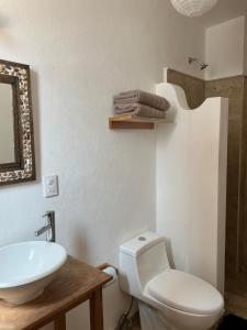Santuario 71 Lofts and apartments في غواناخواتو: حمام مع مرحاض أبيض ومغسلة