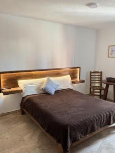 Santuario 71 Lofts and apartments في غواناخواتو: غرفة نوم بسرير كبير مع لوح رأس خشبي