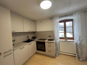 una piccola cucina con mobili bianchi e una finestra di Faraway Homes Studios Bad Leonfelden a Haid Altre 7 foto