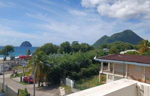 a view of the ocean with mountains in the background at Beau duplex T3 avec une superbe vue mer in Le Diamant