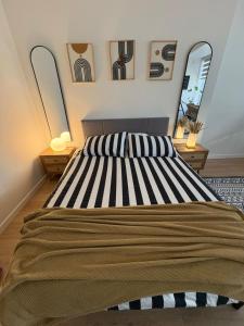 a bedroom with a large bed with two mirrors at Boho Studio Downtown Rogers Views Heated PK in Edmonton