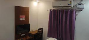 Camera con letto, TV e tenda di Hotel Crossway a Chennai