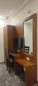 una scrivania con computer e specchio di Hotel Crossway a Chennai Altre 25 foto