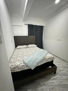 una camera da letto con un letto in una stanza bianca di Sigma Theta Homes - Ayi Mensah a Peduasi