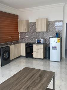 una cucina con frigorifero, lavatrice e asciugatrice di Sigma Theta Homes - Ayi Mensah a Peduasi