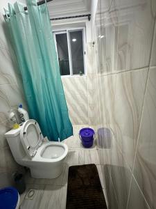 un bagno con un water e una tenda da doccia blu di Sigma Theta Homes - Ayi Mensah a Peduasi