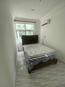 un letto in una stanza con una finestra di Sigma Theta Homes - Ayi Mensah a Peduasi