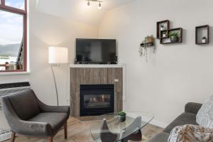 a living room with a fireplace and a tv at Alpenglow Lodge Junior Penthouse by MVA in Whistler