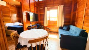 um quarto com uma mesa, um sofá e uma cama em ASA | Chalés Vô Luiz | 2QT | Ar Cond. | Churrasqueira | Próx. à Praia em Gravata