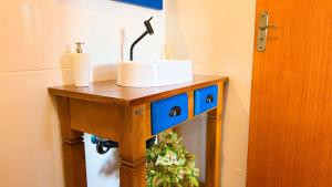 uma mesa de madeira com um lavatório em cima em ASA | Chalés Vô Luiz | 2QT | Ar Cond. | Churrasqueira | Próx. à Praia em Gravata mais 18 fotografias