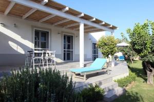 Un patio con una tumbona azul y una pérgola. en Il Giardino di Angelo, en Cava dʼAliga