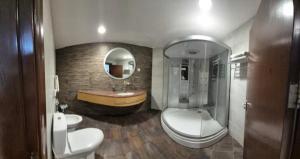 a bathroom with two toilets and a sink and a tub at Le Shot tours Hotel in Al Jafr