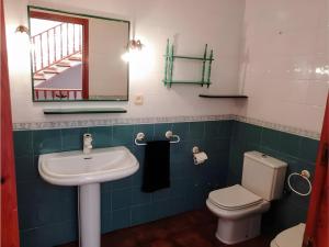 un bagno con lavandino, WC e specchio di Casa rural de estilo rústico a Bonastre Altre 28 foto