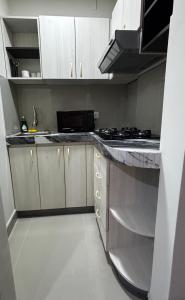 a kitchen with white cabinets and a counter top at Amazon Garden Suites - Recojo del aeropuerto incluido in Pucallpa +46 photos