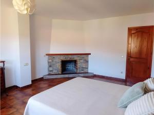 una camera da letto con un letto e un camino di Casa rural de estilo rústico a Bonastre