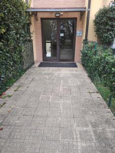 a walkway leading to a building with a glass door at Piccola Oasi in Pantigliate