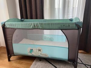 a baby crib with a bed in a room at UrbanNest Aerodrom in Skopje