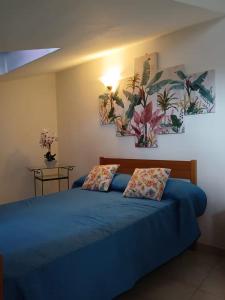 Un dormitorio con una cama azul con dos almohadas. en Casa di Viaggiatori Ciampino, en Ciampino