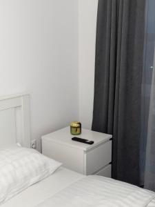 a bedroom with a bed and a nightstand with a clock on it at Luxury Avantgarden apartament in Braşov