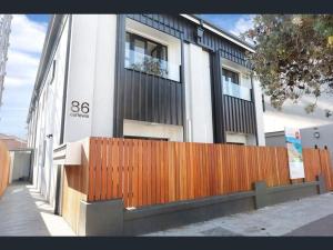 a building with a wooden fence in front of it at Hoffy's Place - Modern one bedroom with AC in Sydney