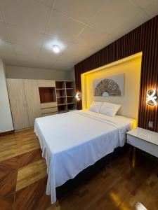 a bedroom with a large white bed in a room at Amazon Garden Suites - Recojo del aeropuerto incluido in Pucallpa