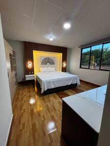 a large bedroom with a bed and a large window at Amazon Garden Suites - Recojo del aeropuerto incluido in Pucallpa