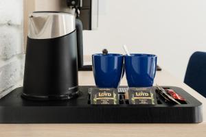 a coffee maker and two blue cups on a table at Aquapark Reda Resort - jedyne noclegi w Aquaparku Reda in Reda