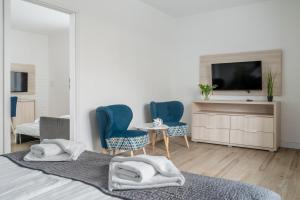 a bedroom with two blue chairs and a tv at Aquapark Reda Resort - jedyne noclegi w Aquaparku Reda in Reda