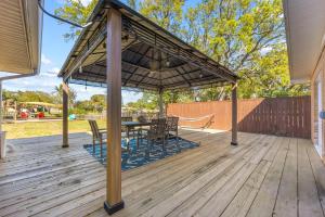 a pavilion with a table and chairs on a wooden deck at Canal-Front Escape w Gazebo Kayaks & Game Room in Cocoa Beach