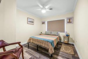 a bedroom with a bed and a ceiling fan at Canal-Front Escape w Gazebo Kayaks & Game Room in Cocoa Beach