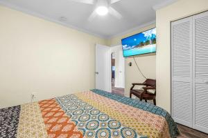 a bedroom with a bed and a flat screen tv at Canal-Front Escape w Gazebo Kayaks & Game Room in Cocoa Beach