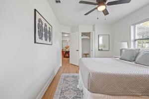 a white bedroom with a bed and a ceiling fan at Island Escape w Private Pool & Outdoor Haven in Merritt Island