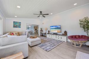a living room with a couch and a tv at 4BR 2-5BA Waterfront Oasis w Pool and Dock in Cocoa Beach