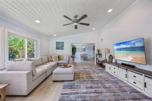 a living room with a couch and a flat screen tv at 4BR 2-5BA Waterfront Oasis w Pool and Dock in Cocoa Beach +50 photos