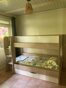 a wooden bunk bed in a room with a window at Fare Panaipo in Uturoa