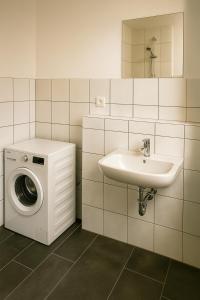 a bathroom with a washing machine and a sink at Monteurzimmer24-Leuna in Leuna