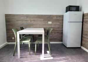 a white table with green chairs and a refrigerator at Monteurzimmer24-Leuna in Leuna +4 photos