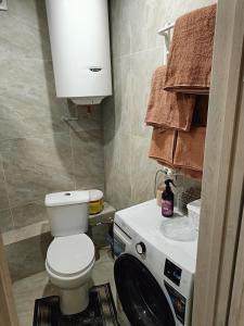 1 комнатные апартаменты في Pavlohrad: حمام مع مرحاض وغسالة ملابس