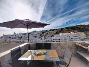 a table with an umbrella on top of a balcony at Panorama Old Town sea view Albufeira in Albufeira