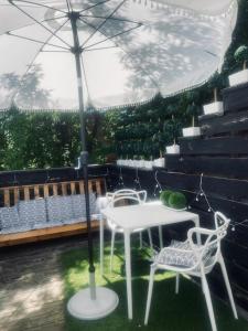 a table and chairs under an umbrella on a patio at Victorian House B&B CozyWestmount in Westmount