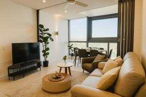 a living room with a couch and a tv at Botanic Serenity - QWR Lv 49 Luxury | BNE River in Brisbane
