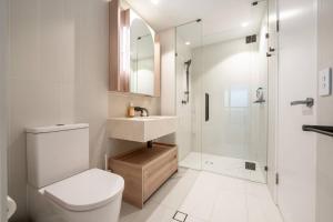 a bathroom with a toilet and a sink and a shower at Botanic Serenity - QWR Lv 49 Luxury | BNE River in Brisbane +21 photos